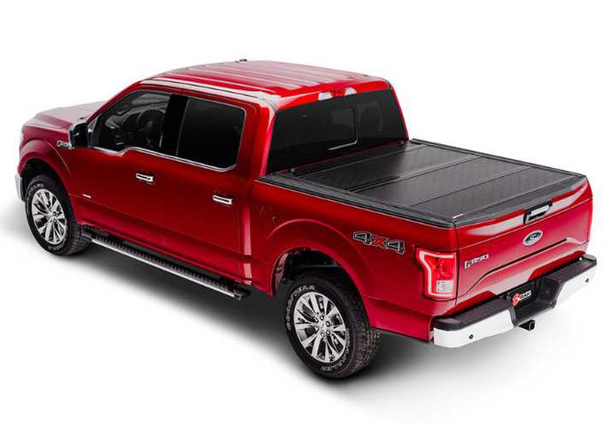 BAKFlip G2 is being displayed closed on a red Ford F150 truck.