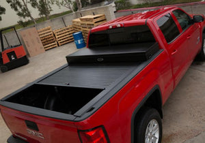 Truck Covers USA Work Cover displayed half way open on a red Chevy Silverado 1500.